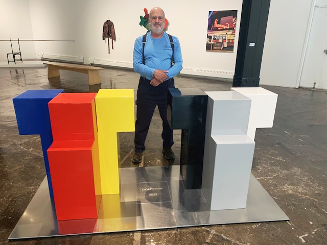 Howard standing with Color and Form at the Three Rivers Arts Festival Juried Exhibition in 2023.